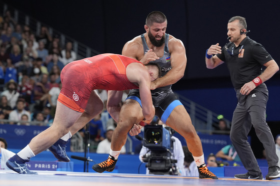 Poland's Robert Baran and Azerbaijan's Giorgi Meshvildishvili compete in their men's freestyle 125-kilogram bronze medal wrestling match at the Paris Olympics at Champ-de-Mars Arena in Paris on Saturday. [AP/YONHAP]