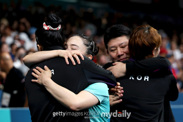 한국 여자 탁구 대표팀 신유빈 이은혜 전지희가 오광헌 감독과 기쁨을 나누고 있다./게티이미지코리아