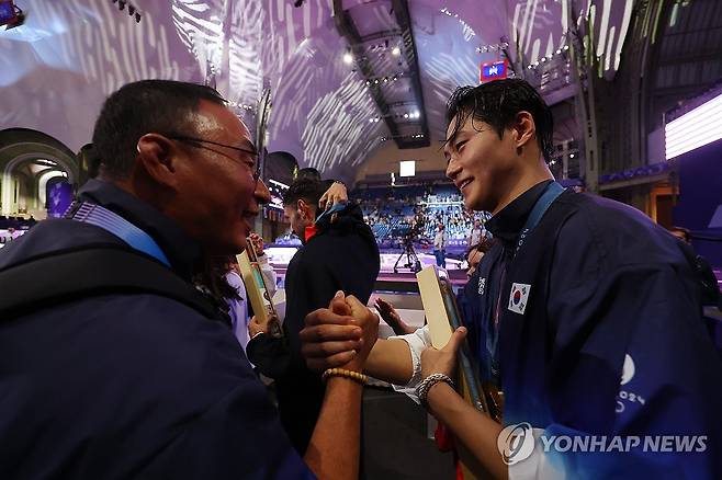 오상욱 축하하는 장재근 선수촌장 (파리=연합뉴스) 김도훈 기자 = 27일(현지시간) 프랑스 파리 그랑 팔레에서 열린 2024 파리올림픽 펜싱 남자 사브르 시상식이 끝난 뒤 장재근 선수촌장이 오상욱을 축하하고 있다. 2024.7.28 superdoo82@yna.co.kr