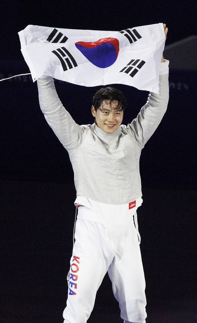 27일(현지시간) 프랑스 파리 그랑 팔레에서 열린 2024 파리올림픽 펜싱 남자 사브르 결승전에서 파레스 페르자니(튀니지)를 꺾고 우승을 차지한 오상욱이 태극기를 펼치며 기뻐하고 있다. 사진=연합뉴스
