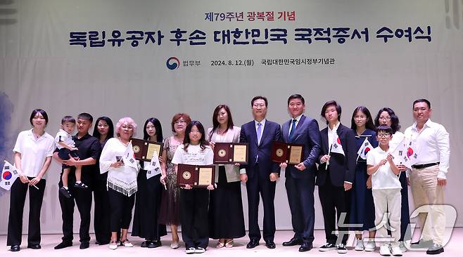 12일 오후 서울 서대문구 대한민국임시정부 기념관에서 열린 독립유공자 후손 국적증서 수여식에서 최찬식 선생의 후손들이 박성재 법무부 장관으로부터 특별귀화증서를 전달받은 후 기념촬영을 하고 있다. 법무부는 이날 독립유공자 후손 27명에게 국적증서를 수여했으며, 지난 2004년부터 현재까지 총 1,392명의 독립유공자 후손에게 대한민국 국적을 부여했다. 2024.8.12/뉴스1 ⓒ News1 오대일 기자