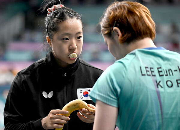 신유빈이 10일(현지시각) 열린 2024파리올림픽 동메달 결정전 독일과 경기에서 선배 이은혜에게 바나나를 까주고 있다. 파리/올림픽사진공동취재단