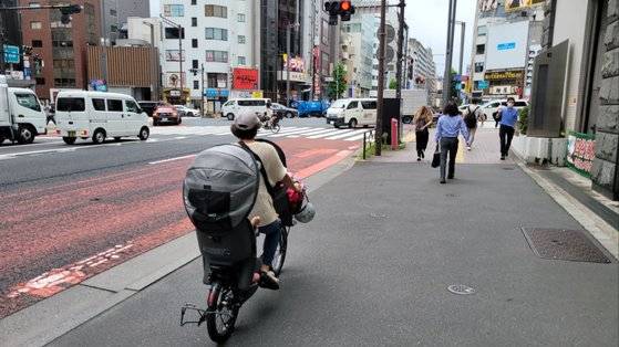 지난 8일 오전 8시경 일본 도쿄에서 한 여성이 아이를 태우고 지나가고 있다. 도쿄=김현예 특파원