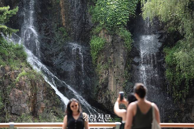 말복을 이틀 앞둔 12일 서울 서대문구 홍제천 인공폭포 앞으로 외국인들이 지나가고 있다. 무더위와 열대야는 당분간 지속될 것으로 보인다. 김창길기자