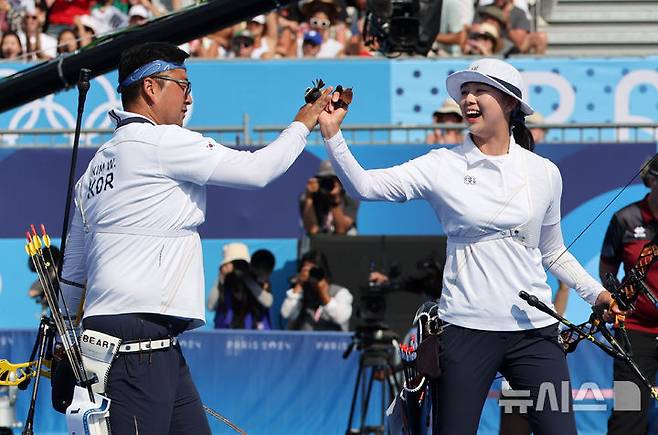 [파리=뉴시스] 김진아 기자 = 김우진-임시현이 2일(현지시각) 프랑스 파리 레쟁발리드에서 열린 2024 파리 올림픽 양궁 혼성 단체 결승 독일과의 경기에서 승리하며 금메달을 확정한 뒤 기뻐하고 있다. 2024.08.03. bluesoda@newsis.com