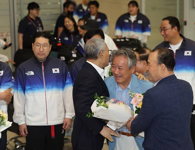 유인촌 문화체육관광부 장관이 13일 오후 인천국제공항 제2여객터미널을 통해 귀국한 이기흥 대한체육회장과 인사를 나누고 있다(사진=연합뉴스).