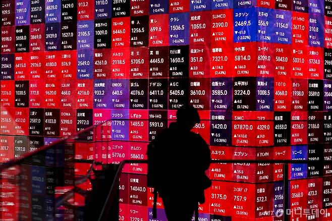 도쿄에서 닛케이지수 개별 종목 증시를 보여주는 전광판 앞에 한 남성이 서 있다.  ⓒ AFP=뉴스1