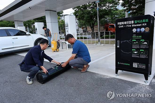 전기차 화재 진압용 질식소화포 (포항=연합뉴스) 손대성 기자 = 13일 경북 포항시 남구 대도동 포항야구장 앞 전기자동차충전소에서 포항시시설관리공단 직원들이 전기차 화재 진압용 질식소화포와 장비를 점검하고 있다.
    공단은 최근 전기차 화재에 대비해 이곳에 질식소화포를 설치했다. 2024.8.13 sds123@yna.co.kr