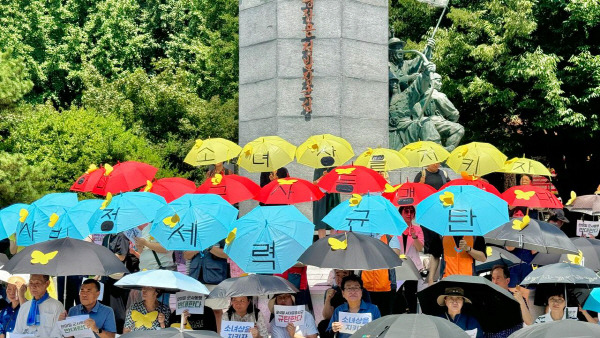 소녀상을 지키는 부산시민행동 등 시민단체가 14일 낮 부산 동구 정발장군 동상 앞에서 ‘8·14 기림일 부산수요집회’를 열고 평화우산을 펼치는 퍼포먼스를 진행하고 있다. 소녀상을 지키는 부산시민행동 제공