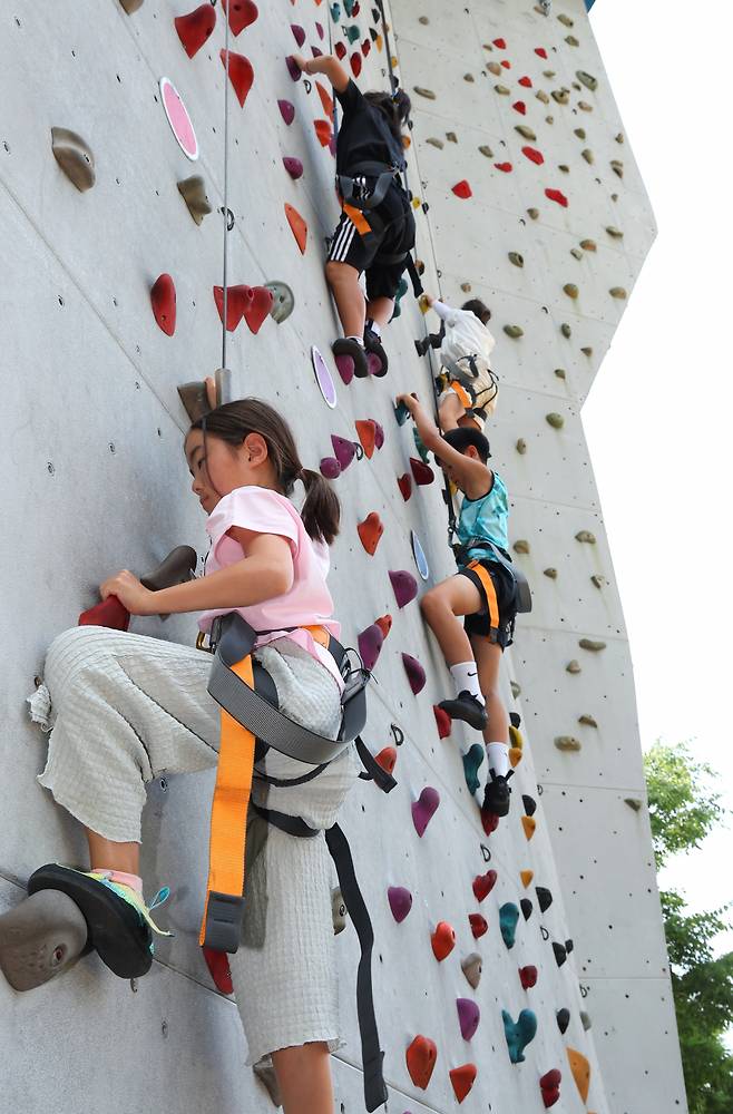 Elementary school students who participated in "2024 Neulbom Summer School" learn top rope climbing at the Busan City Office of Education's Student Character Education Center in Geumjeong-gu, Busan, Aug. 6. (Yonhap)