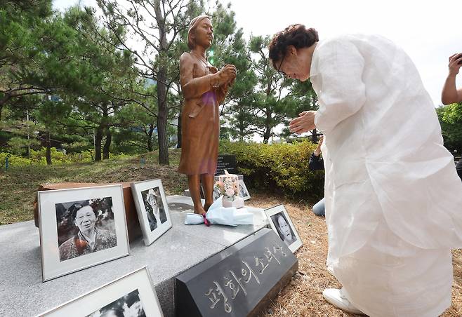 Lee Yong-soo, a 96-year-old survivor of Japan's wartime sexual slavery, lays flowers at the Statue of Peace at Daegu Girls' Commercial High School in Daegu on Wednesday to mark International Memorial Day for Comfort Women that falls on August 14. Some 200,000 Asian women, mostly Koreans, were forcibly sent to front-line brothels to work as sex slaves, euphemistically called "comfort women," for Japanese troops during World War II. (Yonhap)