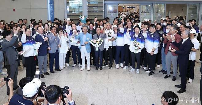 (인천공항=뉴스1) 이기흥 대한체육회장과 체육회 임원들이 입국장 게이트 앞에서 구호를 외치고 있다. 파리 올림픽 국가대표 선수단의 금의환향을 축하하기 위한 정부 공식 환영 행사는 대한체육회의 갑작스런 불참 통보로 취소됐다. 정부 대표로 행사를 준비한 유인촌(오른쪽 끝) 문체부 장관은 한 편에 서 있다.