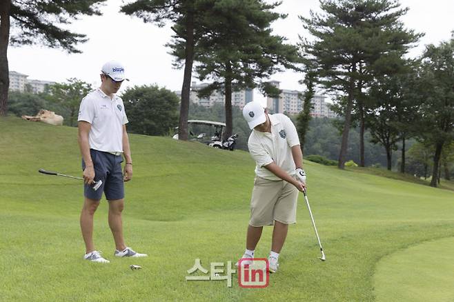 KPGA 프로골퍼 김태훈이 유소년 골프 캠프에 참가한 주니어 선수의 스윙을 지켜보고 있다. (사진=KPGA)