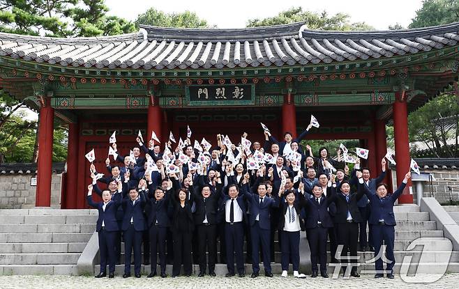 박찬대 더불어민주당 대표 직무대행 겸 원내대표를 비롯한 지도부가 제79주년 광복절인 15일 오전 서울 용산구 효창공원에서 임정요인(이동녕·조성환·차리석) 묘역 참배에 앞서 태극기를 들고 만세삼창을 하고 있다. 2024.8.15/뉴스1 ⓒ News1 김민지 기자