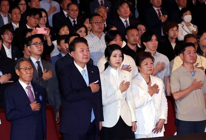 윤석열 대통령과 김건희 여사가 15일 서울 종로구 세종문화회관에서 열린 제79주년 광복절 경축식에서 이동일 순국선열유족회장 등 참석자들과 함께 국기에 대한 경례를 하고 있다. [이미지출처=연합뉴스]