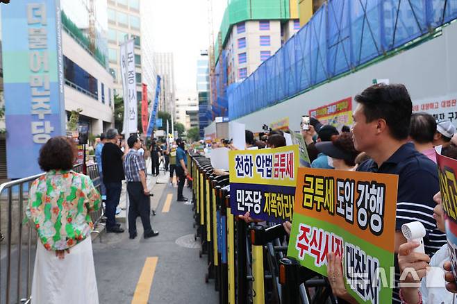 [서울=뉴시스] 권창회 기자 = 한국주식투자자연합을 비롯한 12개 투자자 단체 회원들이 15일 오후 서울 여의도 더불어민주당 당사 앞에서 열린 금투세 폐지 촉구 집회에서 금투세 폐지 손피켓을 들고 있다. 2024.08.15. kch0523@newsis.com