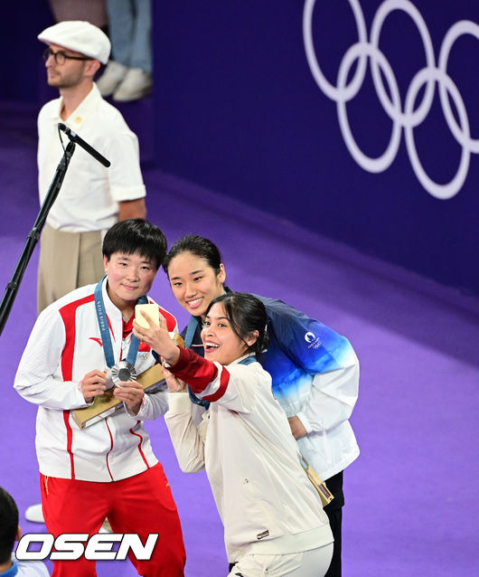 [OSEN=파리(프랑스), 최규한 기자] 5일(한국시간) '셔틀콕 여제' 안세영(22, 삼성생명)이 꿈에 그리던 올림픽 금메달을 목에 걸었다.세계 랭킹 1위 안세영은 5일 오후(이하 한국시간) 프랑스 파리 포르트 드 라샤펠 경기장에서 열린 2024 파리올림픽 배드민턴 여자 단식 결승전에서 랭킹 9위 허빙자오(중국)를 2-0으로 꺾고 금메달을 획득 했다.  금메달 한국 안세영(가운데)와 은메달 중국 허빙자오, 동메달 인도네시아 툰중이 시상대에서 기념촬영을 있다. 2024.08.05 / dreamer@osen.co.kr