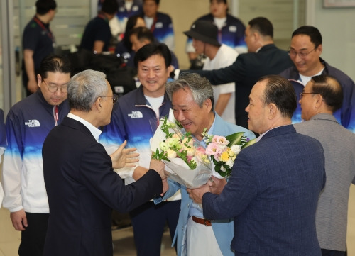 이기흥 대한체육회장이 13일 오후 인천국제공항 제2여객터미널을 통해 귀국해 유인촌 문화체육관광부 장관과 인사를 나누고 있다.  연합뉴스