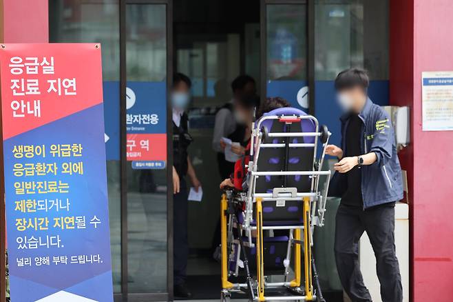 A paramedic carries a patient to the emergency room of a hospital in Seoul, South Korea. / Yonhap