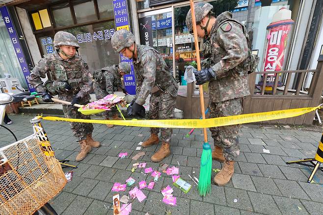 Soldiers collect the contents of a trash-carrying balloon sent by North Korea that landed in Bupyeong-gu, Incheon, July 24. (Yonhap)