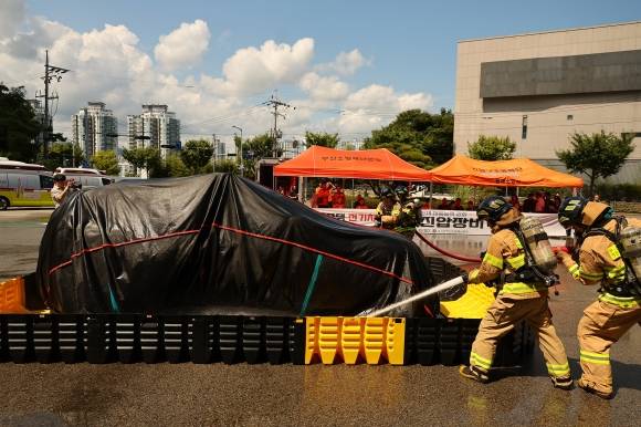 이동식소화수조를 활용한 전기차 진화 - 14일 오후 부산 연제구 부산소방재난본부에서 소방대원들이 전기차 화재 진화 시연을 하고 있다. 이날 진화 시연은 질식소화덮개, 이동식자립방수총, 이동식소화수조 등 전기차 화재 진화 방법이 소개됐다. 2024.8.14 연합뉴스