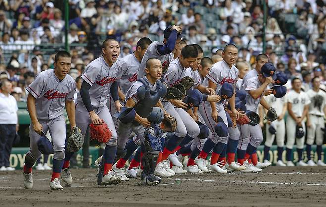 일본 내 한국계 민족학교인 교토국제고 야구 선수들이 17일 일본 효고현 니시노미야 한신고시엔구장에서 열린 전국고교야구선수권대회(여름 고시엔) 3차전에서 4-0으로 승리해 8강 진출을 확정한 뒤 환호하며 달려가고 있다./교도 연합뉴스