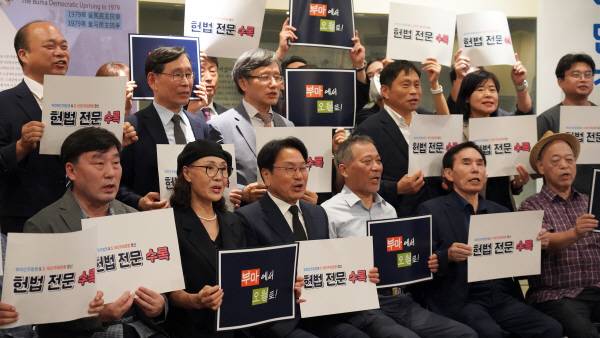 지난 16일 부산민주공원 늘펼쳐보임방에서 최갑순 부마민주항쟁기념재단 이사장(사진 앞줄 왼쪽 두 번째), 강기정 광주시장(사진 앞줄 왼쪽 세 번째) 등이 부마항쟁과 5.18의 헌법 전문 수록의 뜻을 담은 피켓을 들어보이고 있다.