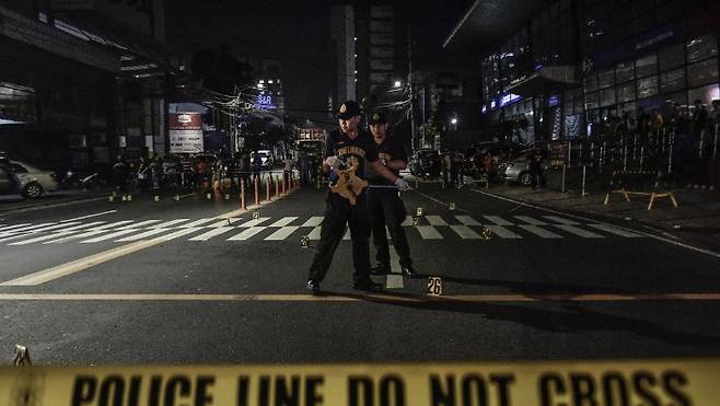 Police officers investigate a crime scene in Manlia, the Philippines in 2017. [EPA/YONHAP]