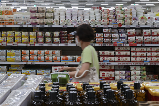 A shopper walks past processed rice products displayed at a discount mart in Seocho District, southern Seoul, on Sunday. [YONHAP]