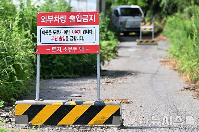 [광주-뉴시스] 이영주 기자 = 16일 오전 광주 서구 마륵동 한 농촌 길에 세워진 통행금지 표지판 뒤로 1t 트럭이 멈춰서있다. 길이 30m·너비 2m 남짓 농로 위에 설치된 해당 표지판은 마을 주민과 토지주 사이 갈등 끝에 토지주가 세운 것으로 전해졌다. 2024.08.16. leeyj2578@newsis.com