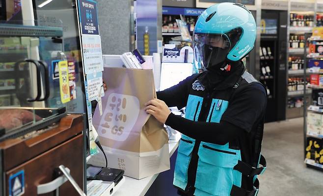 편의점서도 배달 - 18일 오전 서울 강남구 역삼동에 있는 편의점에서 배달 라이더가 고객이 주문한 물건을 픽업하는 모습. 배달의민족과 요기요 등 배달앱들은 고객의 집 앞에 있는 편의점과 정육점, 방앗간, 문구점 물품도 배송해주고 있다. /장련성 기자