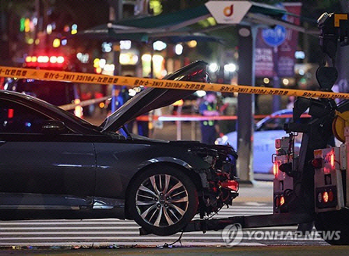 지난 1일 교통사고가 발생한 서울 시청역 인근 교차로에서 경찰이 완전히 파괴된 차량 한 대 주변을 통제하고 있다. 연합뉴스