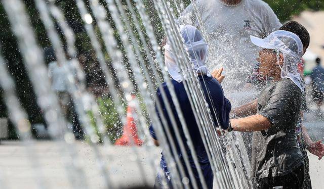 무더위가 이어진 18일 서울 종로구 광화문광장 바닥분수에서 어린이들이 물놀이하며 더위를 식히고 있다. 뉴스1