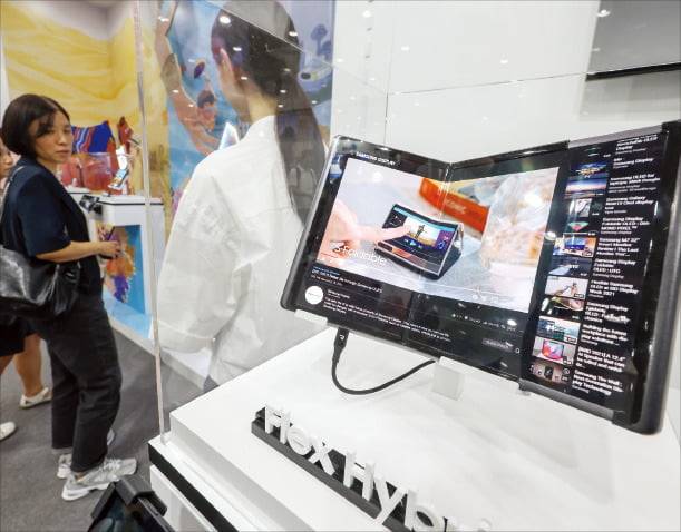 14일 서울 강남구 코엑스에서 열린 ‘2024 한국디스플레이산업 전시회’에 마련된 삼성 디스플레이 부스를 찾은 관람객들이 폴더블 디스플레이를 살펴보고 있다. /뉴스1