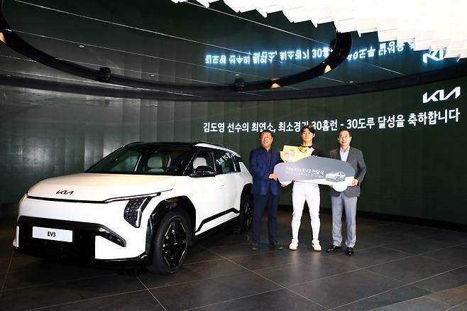 KIA 내야수 김도영(가운데)이 19일 기아 브랜드 체험관인 Kia 360에서 열린 EV3 차량 전달식에서 KIA 타이거즈 최준영 대표이사(왼쪽)와 기아 국내사업본부장 정원정 부사장과 함께 사진 촬영을 하고 있다. 역대 최연소 및 최소경기 30홈런-30도루를 달성한 김도영은 기아로부터 신형 전기차인 EV3(사진 왼편)를 선물로 받았다. 사진제공｜KIA 타이거즈