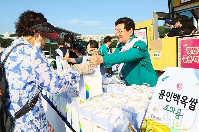 19일 용인시청 하늘광장에서 열린 '용인백옥쌀 아침밥 먹기 캠페인'에서 이상일 시장이 시민들에게 주먹밥을 전달하고 있는 모습.(용인시 제공)