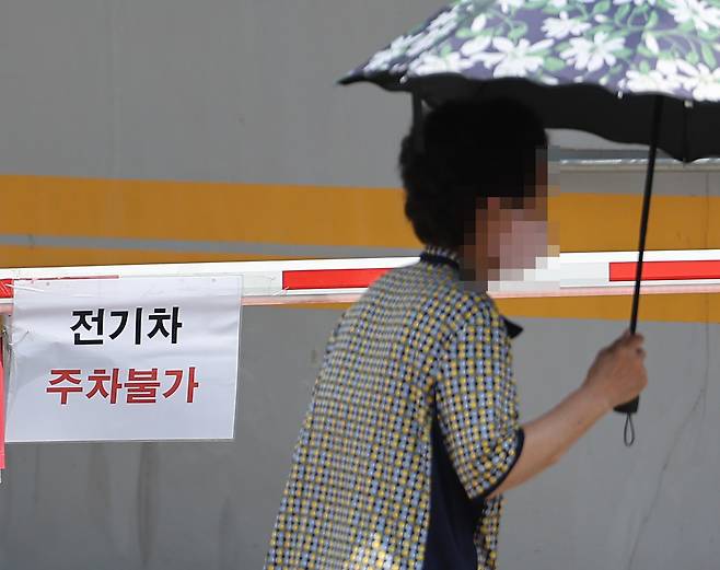 A notice bans EVs from entering an underground parking garage in a building in Seoul on Aug. 13. [YONHAP]