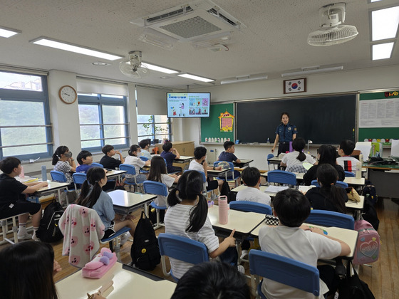 Police officers of Gwangju Nambu Police Station holds classes to educate students on safety measures of electronic scooters at Jinnam Elementary School in Nam Distract, Gwangju, on July 25. [YONHAP]