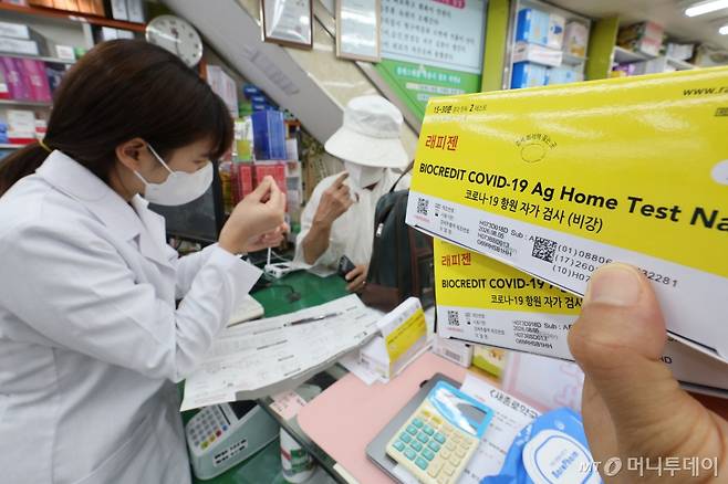 (서울=뉴스1) 신웅수 기자 = 신종 코로나바이러스 감염증(코로나19)이 재유행하고 있는 18일 서울 종로구 새종로약국에서 약사가 코로나19 자가 키트를 구매하는 고객에게 사용법을 알려주고 있다.  코로나19 환자가 6주 만에 약 22배로 폭증하면서 치료제와 진단키트 품귀 현상이 전국 곳곳에서 발생하고 있다.  생산공장에서는 재고가 바닥나 공장을 풀가동하고 있는 상황이며 진단키트 제조업체들은 이번주 공급 물량도 납품 예약이 완료될 정도로 제품 조달에 어려움을 겪고 있다. 2024.8.18/뉴스1  Copyright (C) 뉴스 /사진=(서울=뉴스1) 신웅수 기자