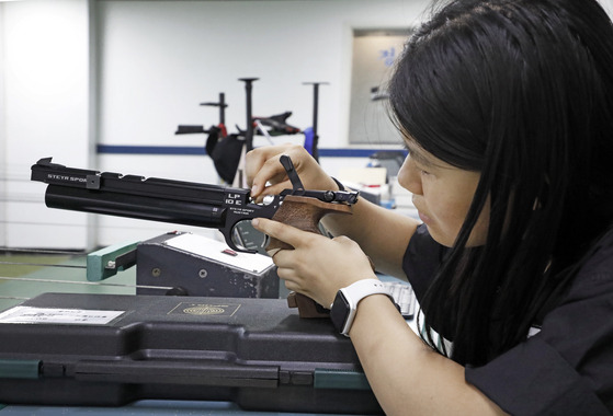 Mary loads the bullet into the pistol. She's locked in. [PARK SANG-MOON]