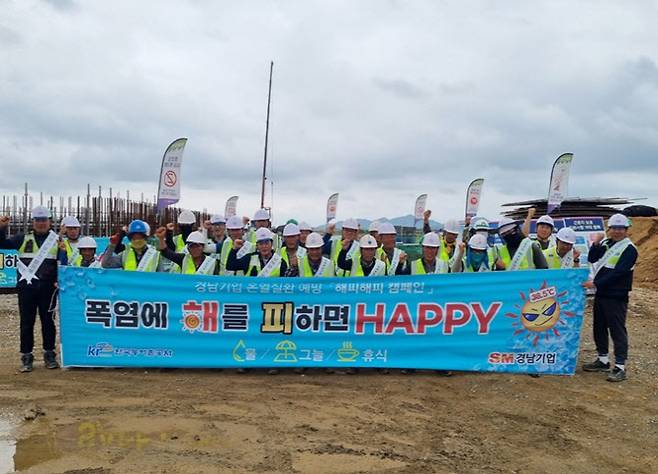 경남기업의 전남 무안군 영산강 4지구 농업개발사업 현장 근로자들이 혹서기 온열질환 예방을 위한 ‘해피해피 캠페인’의 성공적인 운영을 기원하며 기념촬영을 하고 있다. (사진=SM그룹)