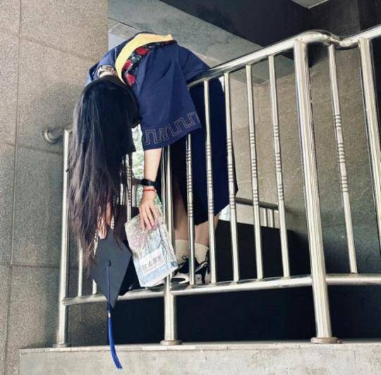 중국의 한 대학생이 졸업식에서 학교 난간에 마치 시신처럼 매달려 있는 퍼포먼스를 하고 있다. 대학을 졸업해도 취업이 안 되는 절망적 심경을 표현하고 있다. 샤오훙수 캡처