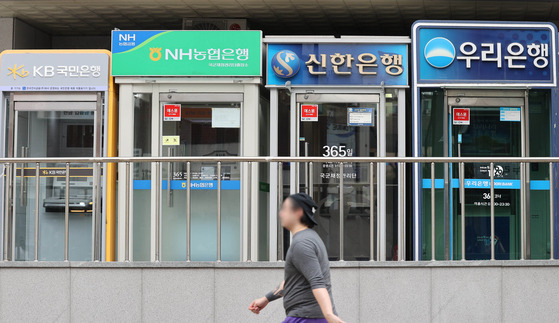 A person walks past a bank of ATM booths in Yongsan District, central Seoul, on Thursday. [YONHAP]