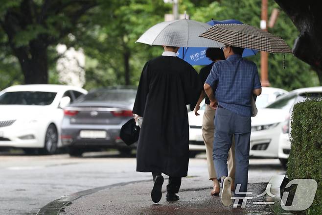 21일 경기 용인시 기흥구 경희대학교 국제캠퍼스에서 열린 '2023학년도 후기 학위수여식'에서 졸업생이 우산을 쓰고 걸어가고 있다. 2024.8.21/뉴스1 ⓒ News1 김영운 기자