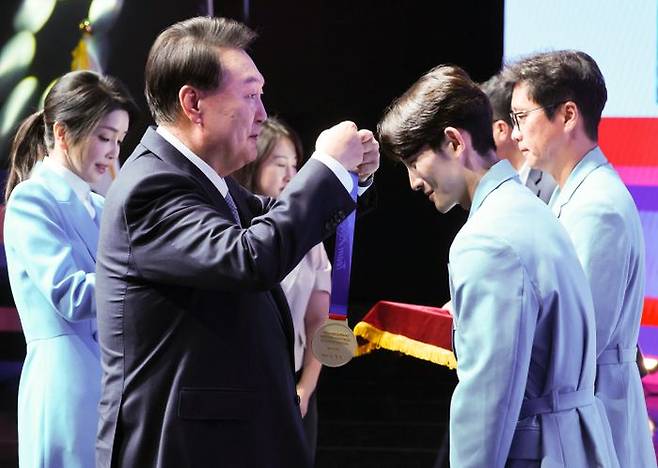 윤석열 대통령이 22일 서울 한 호텔에서 열린 2024 파리올림픽 선수단 격려 행사에서 스포츠클라이밍 신은철에게 국민감사 메달을 수여하고 있다. ⓒ뉴시스