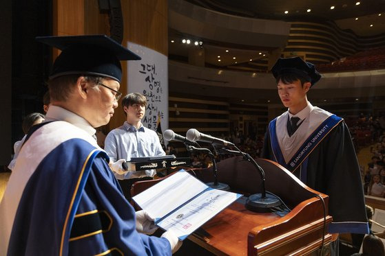 학위수여식에서 학위를 수여하는 장면.