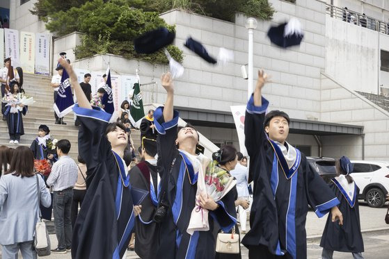 학위수여식에서 학사모를 던지며 졸업을 축하하는 학생들.