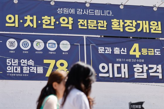 People pass by a flyer advertising medical school admissions in Daechi-dong, Gangnam District, in southern Seoul, in April. [NEWS1]