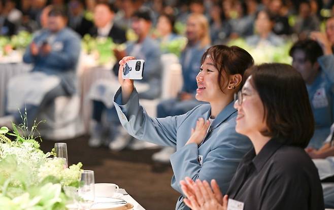 합창단 하모나이즈의 공연을 스마트폰으로 촬영하고 있는 올림픽 참가 선수들/대통령실 제공