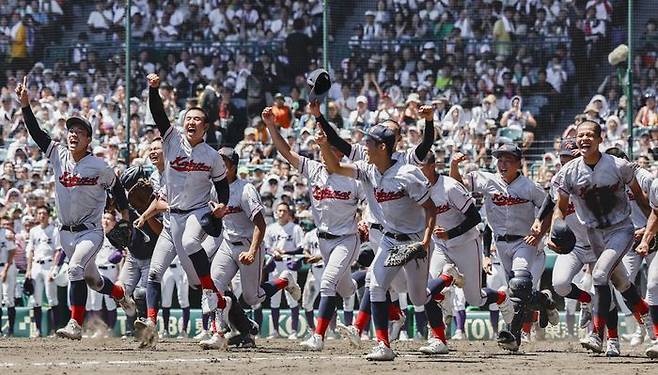 한국계 국제학교인 교토국제고 선수들이 23일 일본 효고현 니시노미야 한신고시엔구장에서 열린 전국 고교야구선수권대회(여름 고시엔) 결승전에서 간토다이이치고를 2-1로 이기고 우승한 뒤 응원석 쪽으로 달려가고 있다.ⓒ 연합뉴스